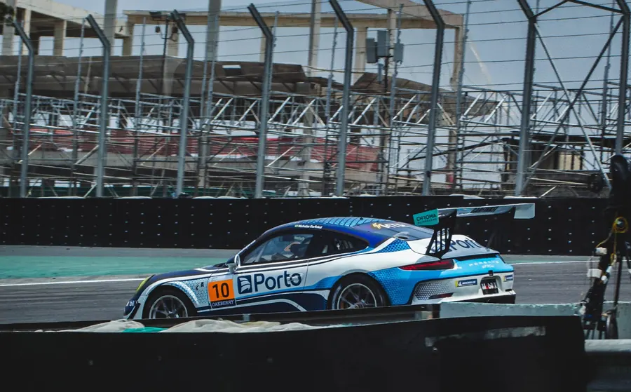 Carro azul e branco passando em frente à arquibancada