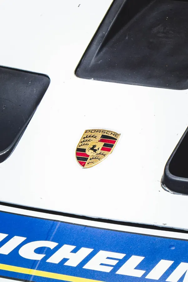 Brasão da Porsche no capô branco, com faixa azul abaixo