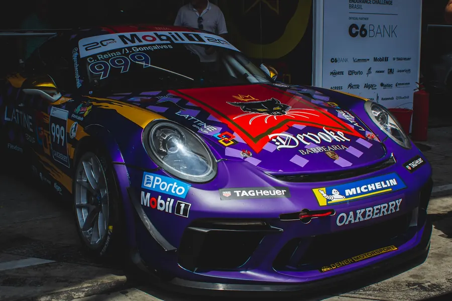 Porsche roxo com pintura especial estacionado no paddock