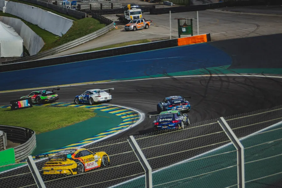 Grupo de carros disputando posição em uma curva de Interlagos